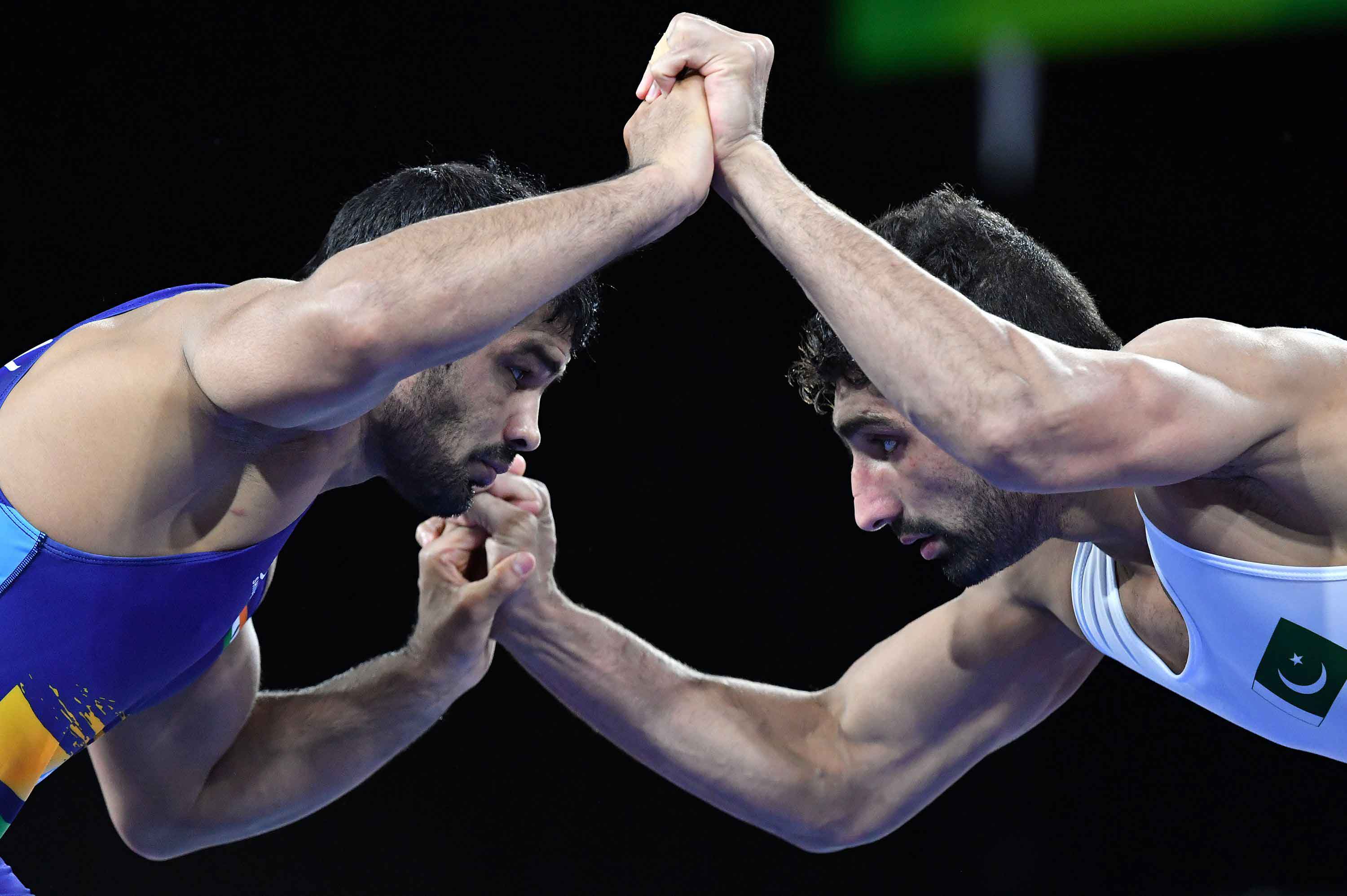 In Pictures: Pakistan's Asad Butt wrestles with India's Kumar Sushil during Commonwealth Games