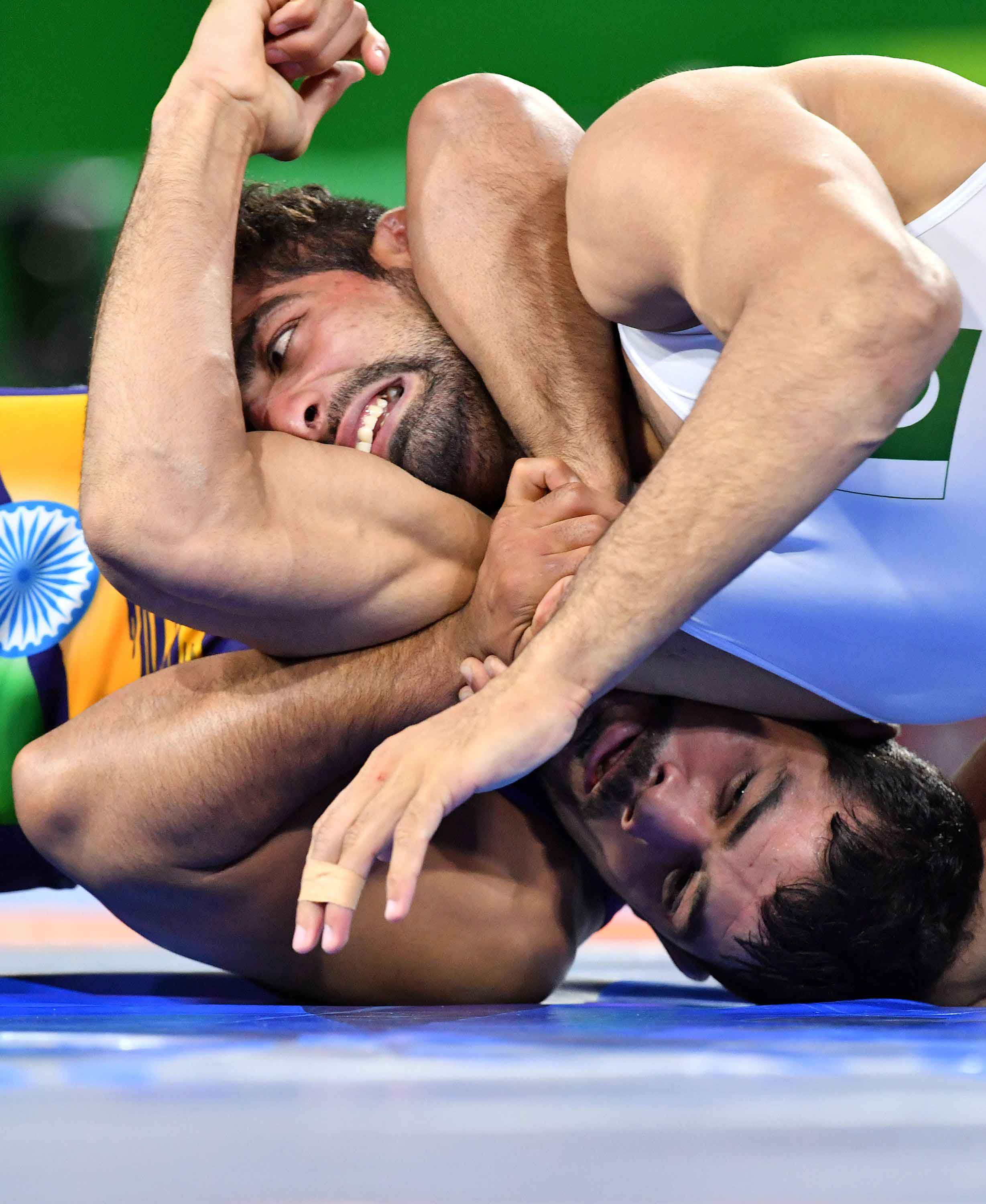 In Pictures: Pakistan's Asad Butt wrestles with India's Kumar Sushil during Commonwealth Games