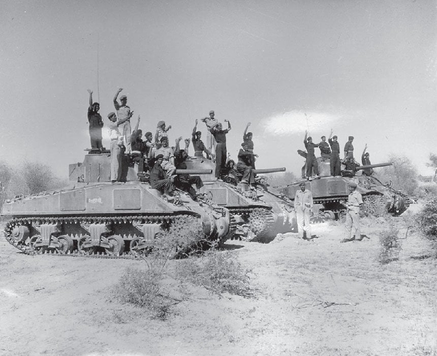 Pakistani soldiers atop captured indian tanks raise slogans of joy.