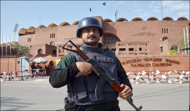 Security personnel standing alert outside the Gaddafi Stadium
