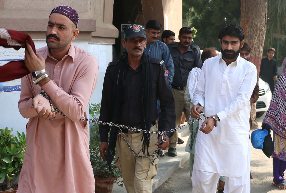 Wasim (R), brother of slain social media celebrity Qandeel Baloch and his cousin, who are accused of killing her, are escorted by policeman as they arrive at a local court in Multan
