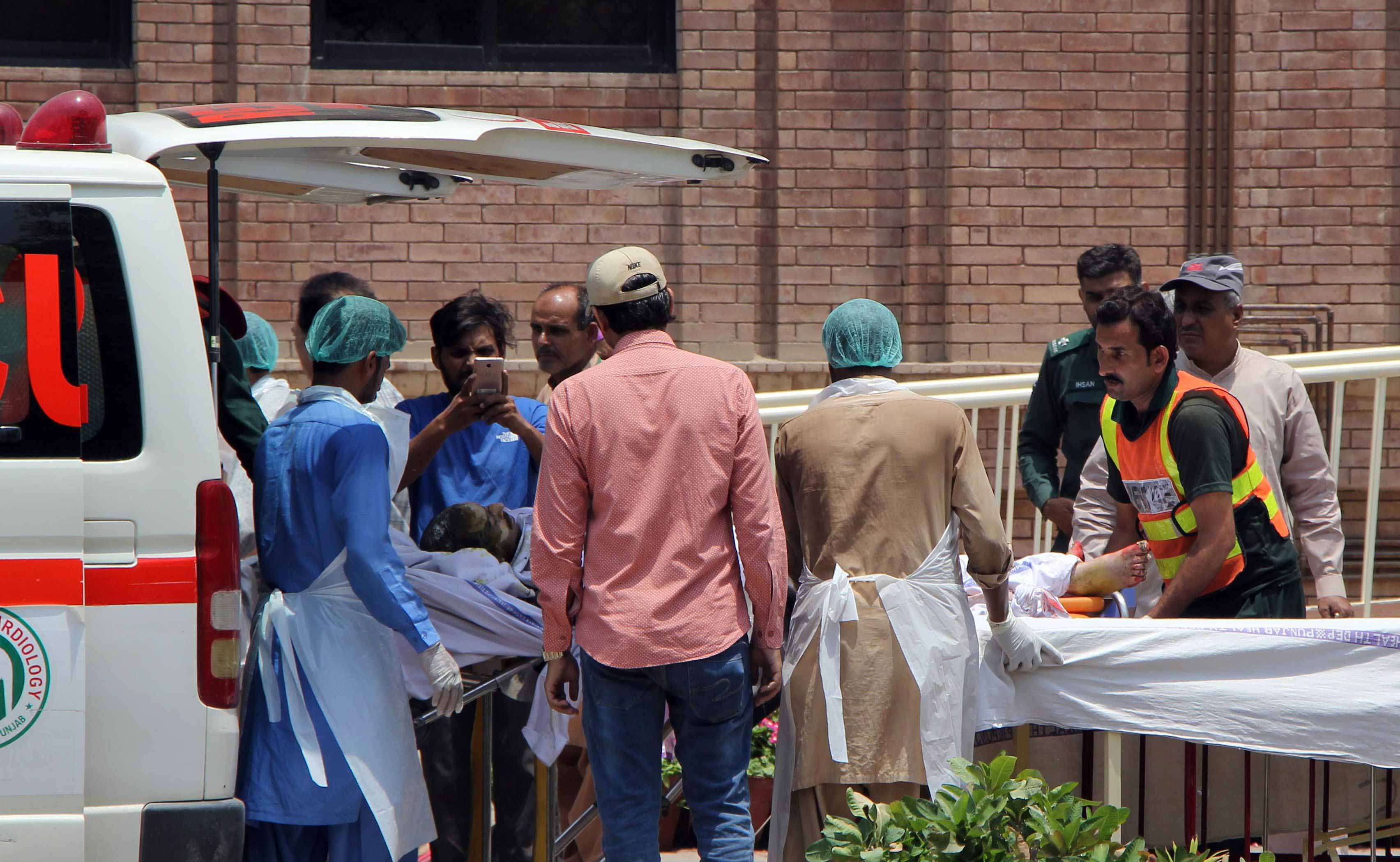 Paramedics bring a burns victim injured after an oil tanker caught fire following an accident on a highway in Bahawalpur to a hospital in Multan.