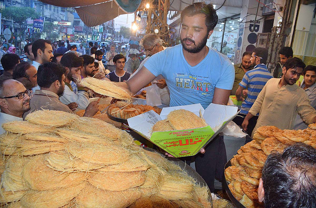 People busy in purchasing traditional sweet item in connection with Shab-e-Barat at Shaheen Chowk, Rawalpindi.
