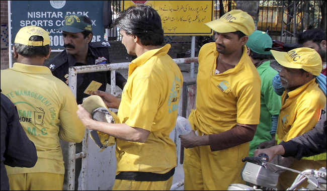 Policeman checks the IDs of workers on the main gate of Gaddafi Stadium