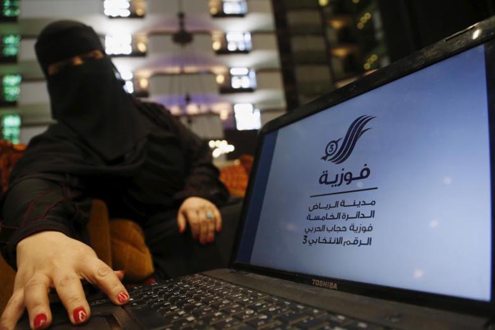 Fawzia al-Harbi, a candidate for local municipal council elections, shows her candidate biography at a shopping mall in Riyadh November 29, 2015. REUTERS