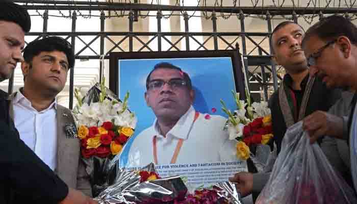 Businessmen put candles and rose petals next to the portrait of a Sri Lankan manager of a sports equipment factory, as they pay tribute to him outside the office of Sialkot Chamber of Commerce and Industry in Sialkot.-File photo
