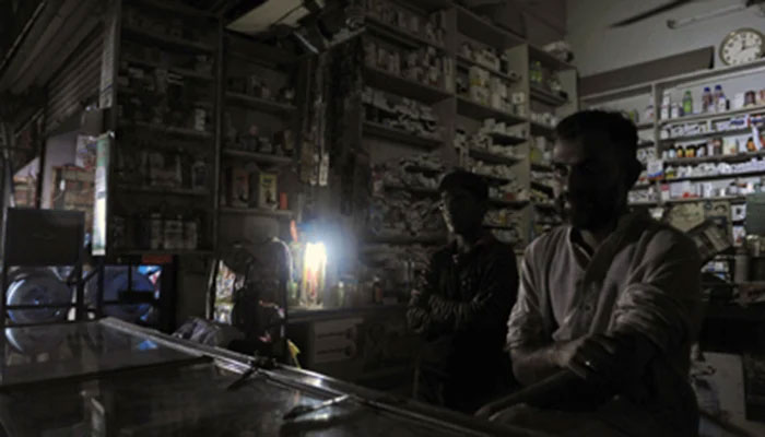 Shopkeeper seen at his shop with no electricity. Photo: The News/File