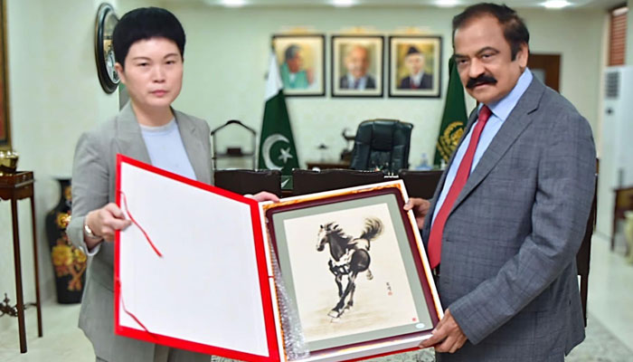 Chinese Charge dAffaires to Pakistan Pang Chunxue presenting a souvenir to Rana Sanaullah on May 10, 2022.