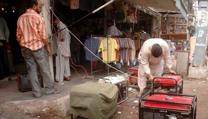 A trader starting a generator as power outages mar the civic life in Pakistan. Photo: The News/File