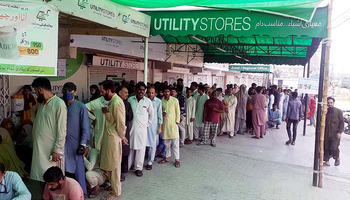People gather in a queue and waiting for their turn to buy edibles at a Utility Stores outlet in Lahore on Sunday, May 01, 2022. -PPI