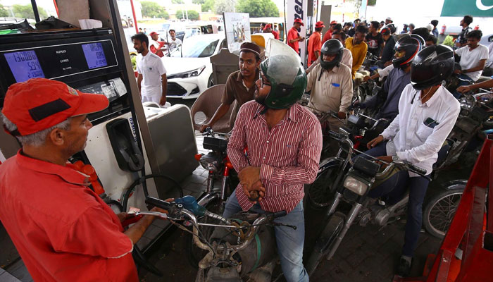 The motorcyclists waiting for getting a refill at a petrol pumping station in Karachi. Photo: INP