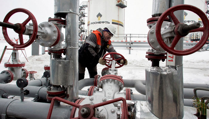 A worker turns a valve at UdmurtNefts Gremikhinskoye oil field east of Izhevsk near the Ural Mountains, Russia, Dec. 7, 2007. Photo: Agencies