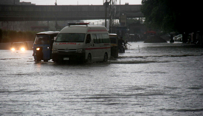An ambulance is stuck in a flooded road during heavy rainfall in Karachi. -Online