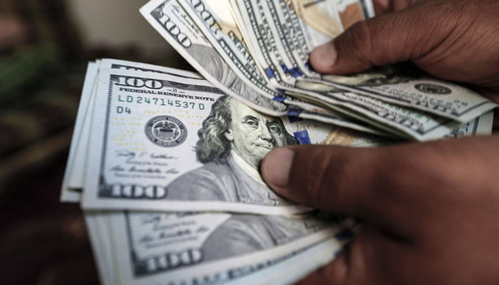 A trader can be seen counting the US currency. &mdash; AFP