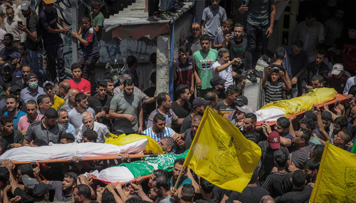 Graphic content / Palestinians carry the bodies of four teenage Palestinians from the Najm family, during their funeral in Jabalia in the northern Gaza Strip on August 8, 2022. —MOHAMMED ABED / AFP