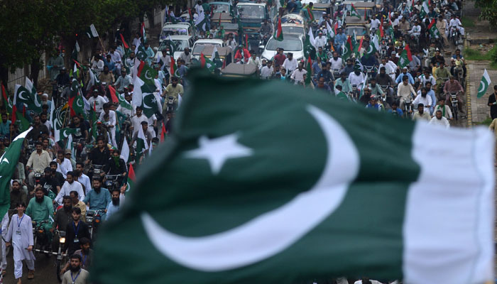 People take part in a march to celebrate Pakistans 75th Independence Day in Karachi on August 14, 2022.—Rizwan TABASSUM / AFP
