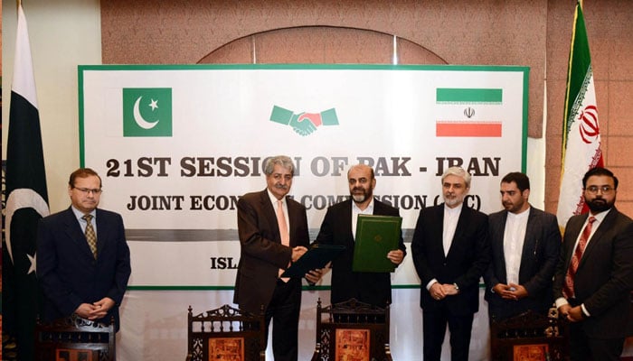 Federal Minister for Commerce, Syed Naveed Qamar and Iranian Road & Urban Development Minister Rostam Gasemi after signing accord. —APP/ Saleem Rana