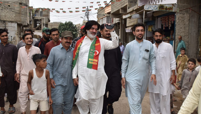 PTIs mayoral candidate for the upcoming local government elections Muhammad Ashraf Jabbar Qureshi waves at constituents during his election campaign in this undated photo. — PTI