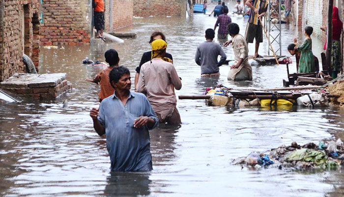 Rain effected people by flash flood after torrential rain are using a floating wooden raft made by ladder at home for transportation in flooded streets at Jinnah colony Latifabad as new heavy spell of monsoon rain hits the city.— APP/ Farhan khan