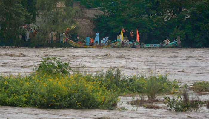 26-Homeless flood affected People shifting to safe places on their boats in Khiyali River, district Charsadda as flash floods wreak havoc—. APP/ Shaheryar Anjum