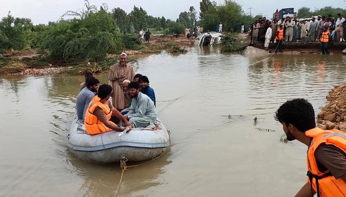 Rescue workers shifting flood effected peoples at Swat Khwazakhela.— INP