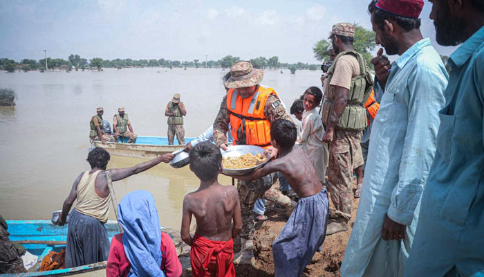 Army officials distributing food to flood affected people. —APP/ Safdar Abbas