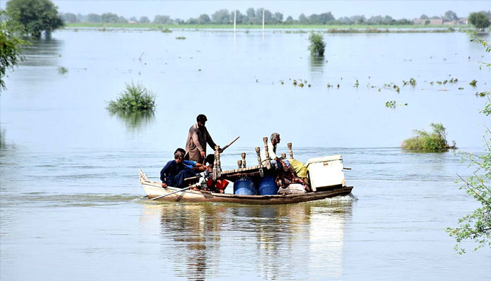 Flood affected people in Katcha area of Indus River along with their household items loaded on boat shifting towards safe place near Larkana-Khairpur Bridge. —APP/ Nadeem Akhtar Soomro