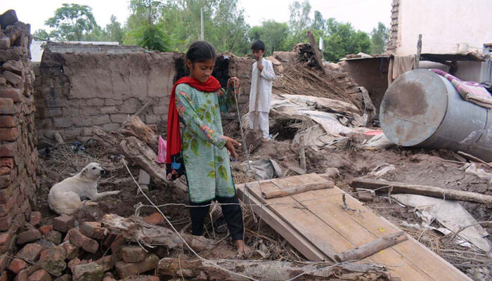 Flood affected children collecting their belongings from their damaged home after the unprecedented deadly flash flood hit the city. —APP /Shaheryar Anjum