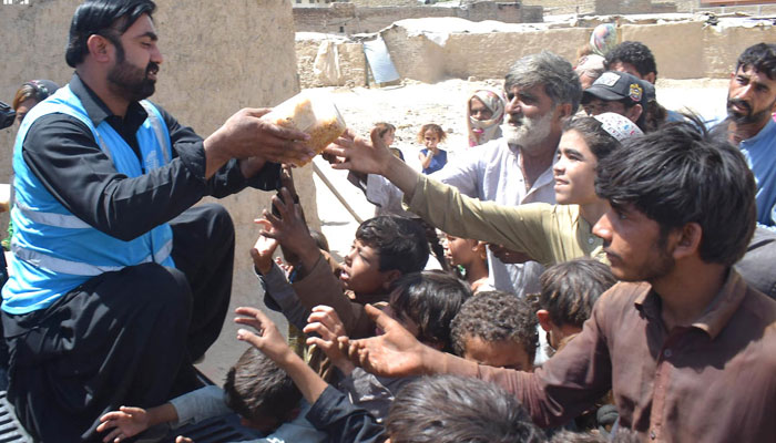 A volunteer distributing food among the flood-affected people in Quetta. INP
