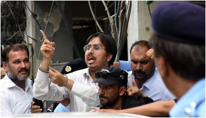 Police officers escort the leader of Pakistan Tehreek-e-Insaaf (PTI) Doctor Shahbaz Gill after a hearing at district court, in Federal Capital. — Online/File