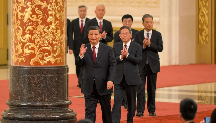 Chinas President Xi Jinping (front) walks with members of the Chinese Communist Partys new Politburo Standing Committee, the nations top decision-making body, as they meet the media in the Great Hall of the People in Beijing on October 23, 2022. — AFP