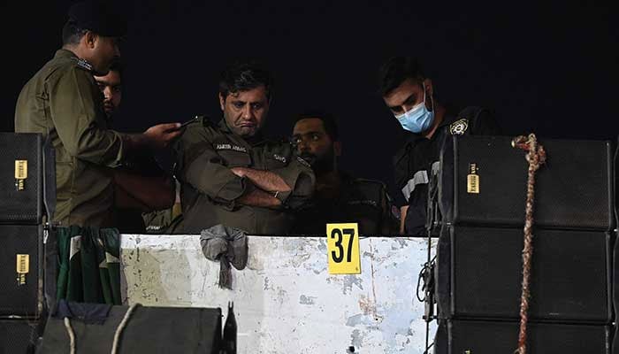 Investigators examine the rooftop of a container truck used by the former prime minister Imran Khan during his political rallies, hours after a gun attack in Wazirabad on November 3, 2022. — AFP