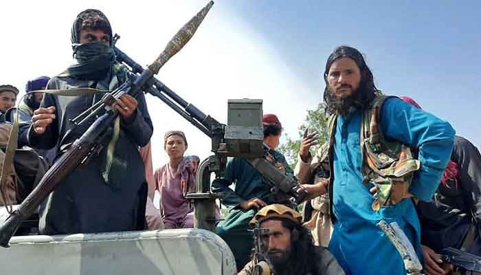Taliban fighters sit over a vehicle on a street in Laghman province on August 15, 2021. — AFP