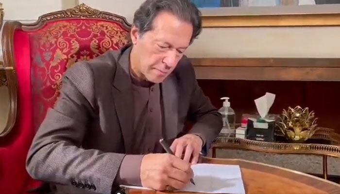Imran Khan writing a letter to the CJP seeking justice for slain journalist Arshad Sharif on December 3, 2022. Screengrab of a Twitter video
