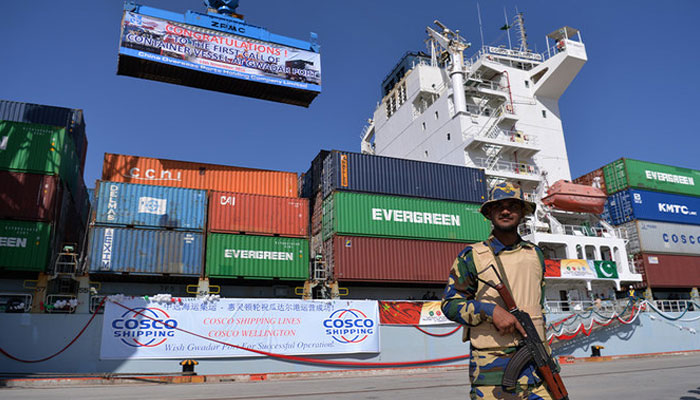 A Pakistani Naval personnel stands guard beside a ship carrying containers during the opening of a trade project in Gwadar port, some 700 kms west of Karachi on November 13, 2016. — AFP