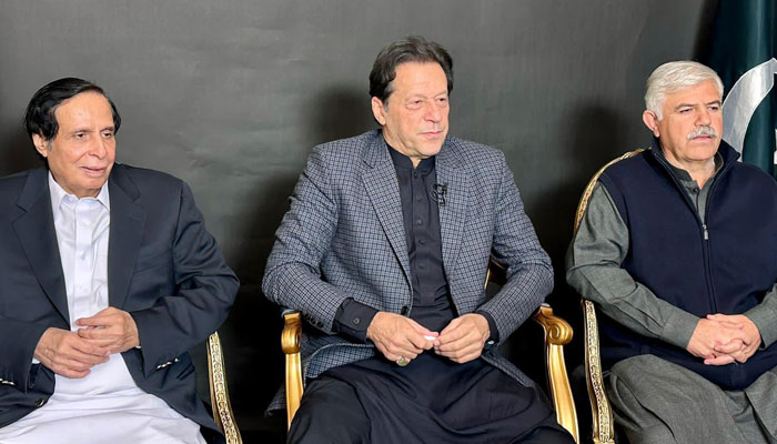 Former PM Imran Khan, flanked by Punjab CM Parvez Elahi (Left) and KP Chief Minister Mahmood Khan, addressing party workers at Liberty Chowk Lahore via video link from his Lahore residence on December 17, 2022.