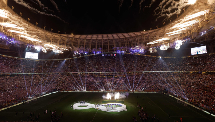 Fireworks blow as Argentinas players (C) attend the Qatar 2022 World Cup trophy ceremony after the football final match between Argentina and France at Lusail Stadium in Lusail, north of Doha on December 18, 2022. —AFP