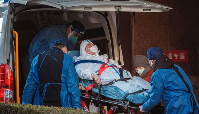 A person is carried into a hospital in Shanghai. Hospitals have been told to sort out their overflowing emergency rooms. Agencies