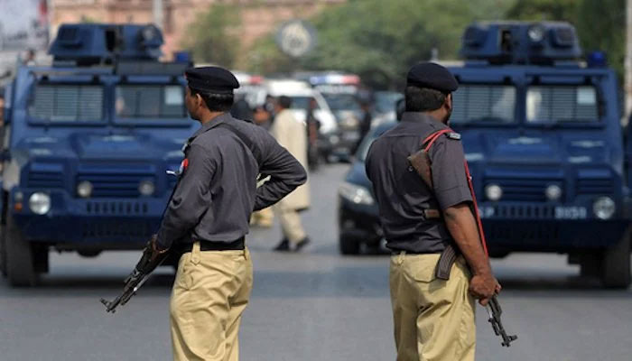 Karachi police personnel stand guard at a road in the city. — AFP/File
