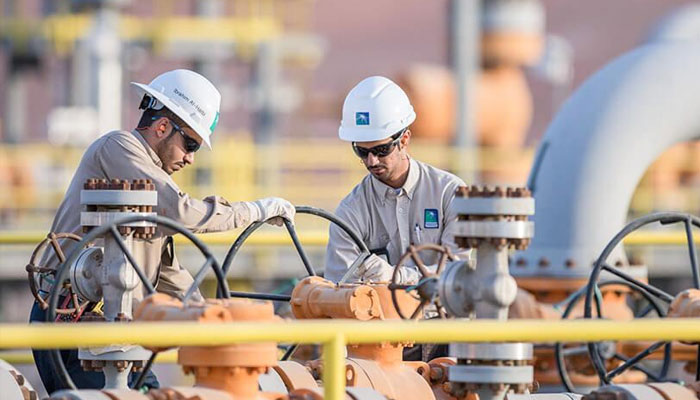 Saudi Aramco employees working on an oil pipeline. — AFP/File