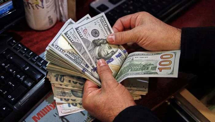 Representational image of a man counting dollar bills. — AFP/File
