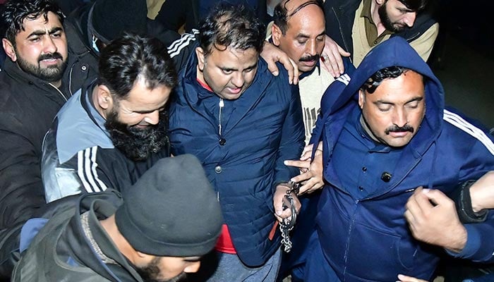 Police officials escort the former information minister Fawad Chaudhry to leaving after hearing in a court in Islamabad on January 25, 2023. — Online