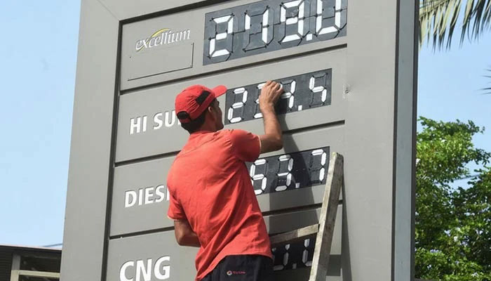 A representational image of a petrol station staffer updating the fuel prices in Karachi. — AFP/ File