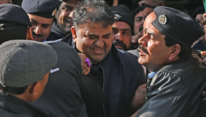 Police officials escort former information minister Fawad Chaudhry as they leave the court after a hearing, in the federal capital on January 27, 2023. — Online/File