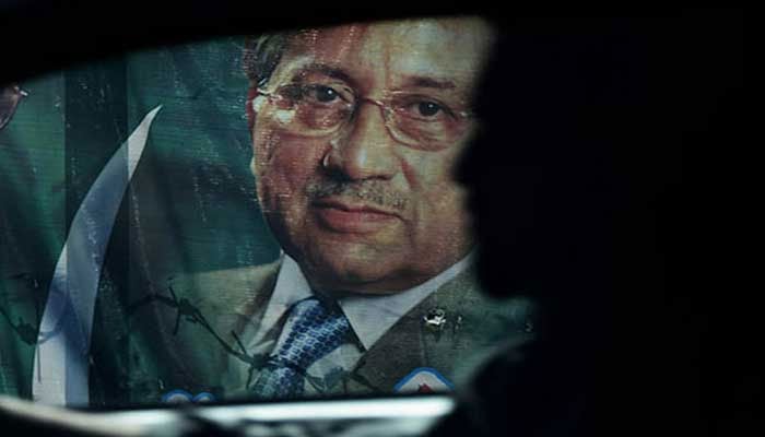 Gen (retd) Pervez Musharrafs picture on a banner seen from the window of a moving car. — AFP/File
