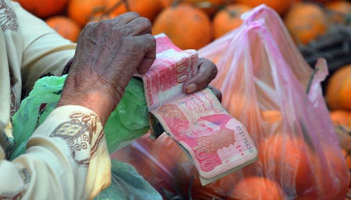 Representational image showing a fruit vendor counting money. — AFP/File