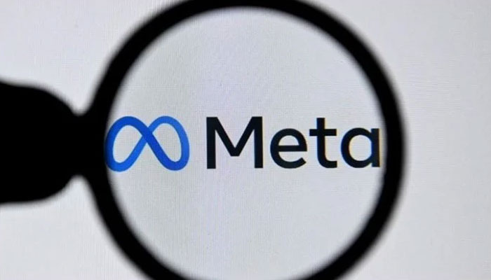 Image showing the logo of Meta as seen through a magnifying glass. — AFP/File