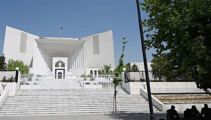 Policemen sit beside Pakistans Supreme Court building during a hearing in Islamabad on April 6, 2022. — AFP/file