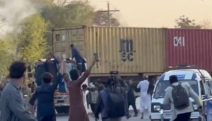 PTI workers protesting in Lahore as police fire tear gas shells at them, on March 8, 2023, in this still taken from a video. — Twitter/@StaunchInsafi