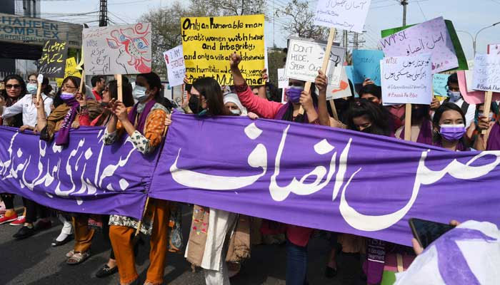 Aurat March activists hold placards during a demonstration to mark International Women´s Day in Lahore on March 8, 2022. — AFP